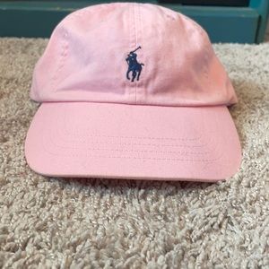 Light pink polo baseball hat. With navy blue emblem.